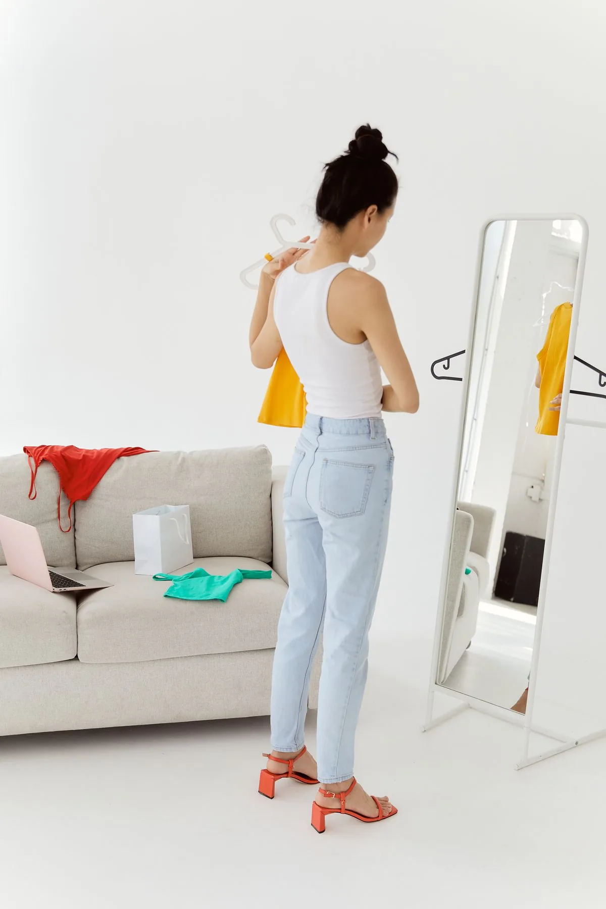Cô gái chọn đồ trước gương trong phòng sáng