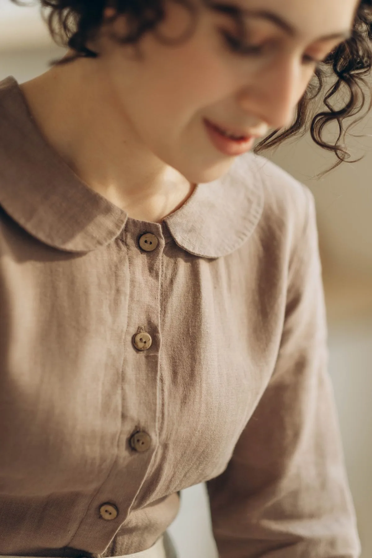 Cô gái mặc áo linen màu nâu nhạt có cổ tròn